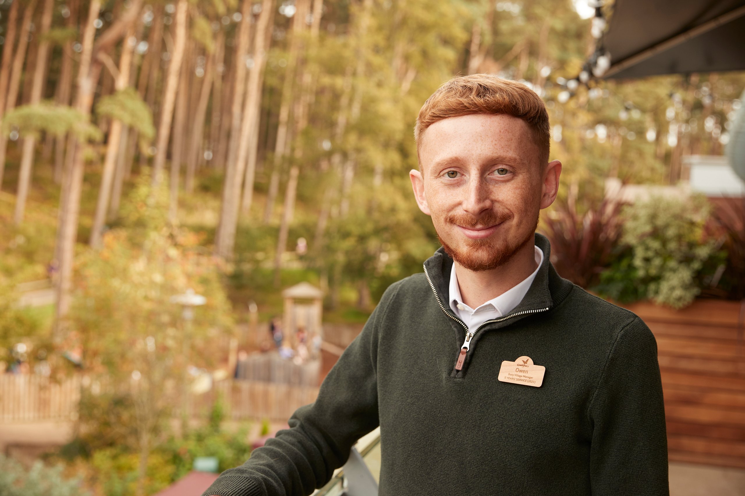 Portrait of a man with red hair, wearing a green sweater.